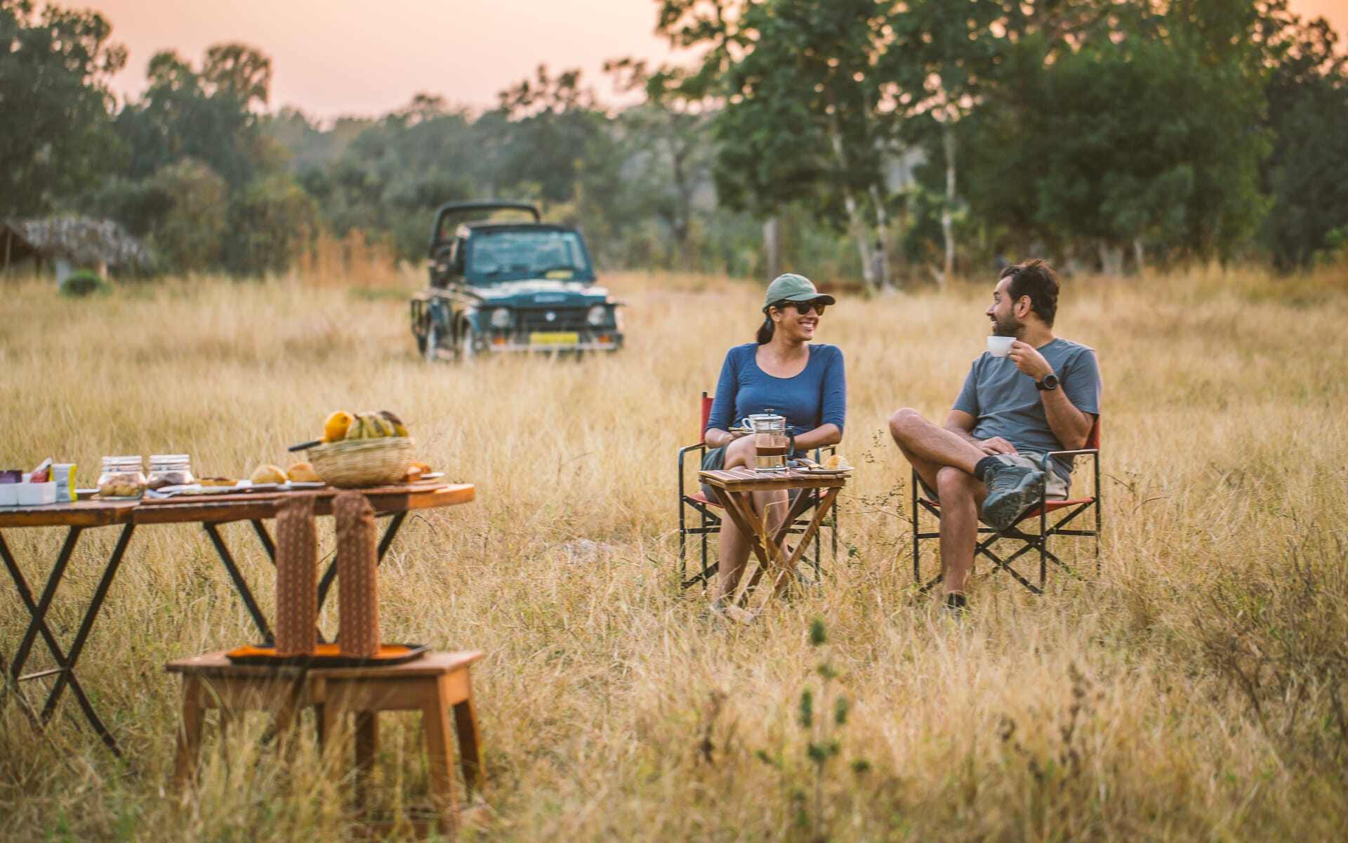 A couple relax in the long grass at Jamtara Wilderness Camp.