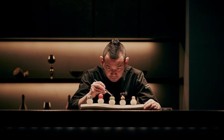 The hotel chef carefully prepares dessert.