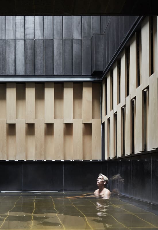 A guest relaxes in the ryokan spa, sourced from local Hot Spring waters.