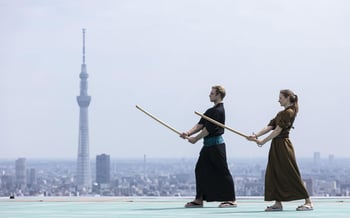 Two people enjoy the "sky high morning Kenjutsu practice" activity at the Japan hotel.