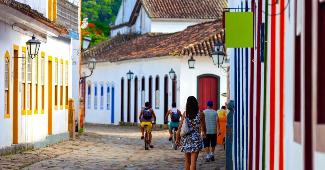 A lady walks through the colourful streets of Paraty, Brazil.