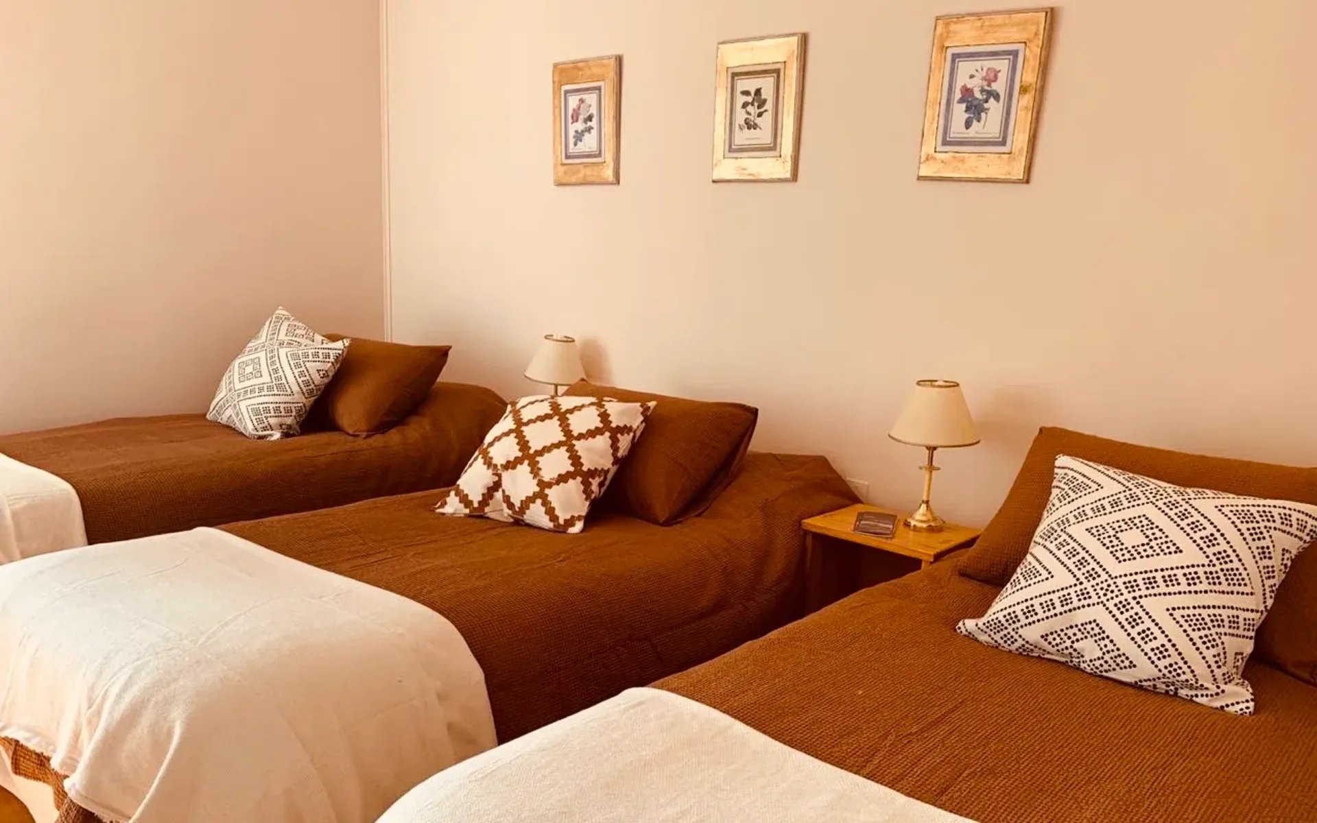 A triple room at the estancia is equipped with comfy beds dressed with chocolate-brown bedding and decorated in a simple style. 