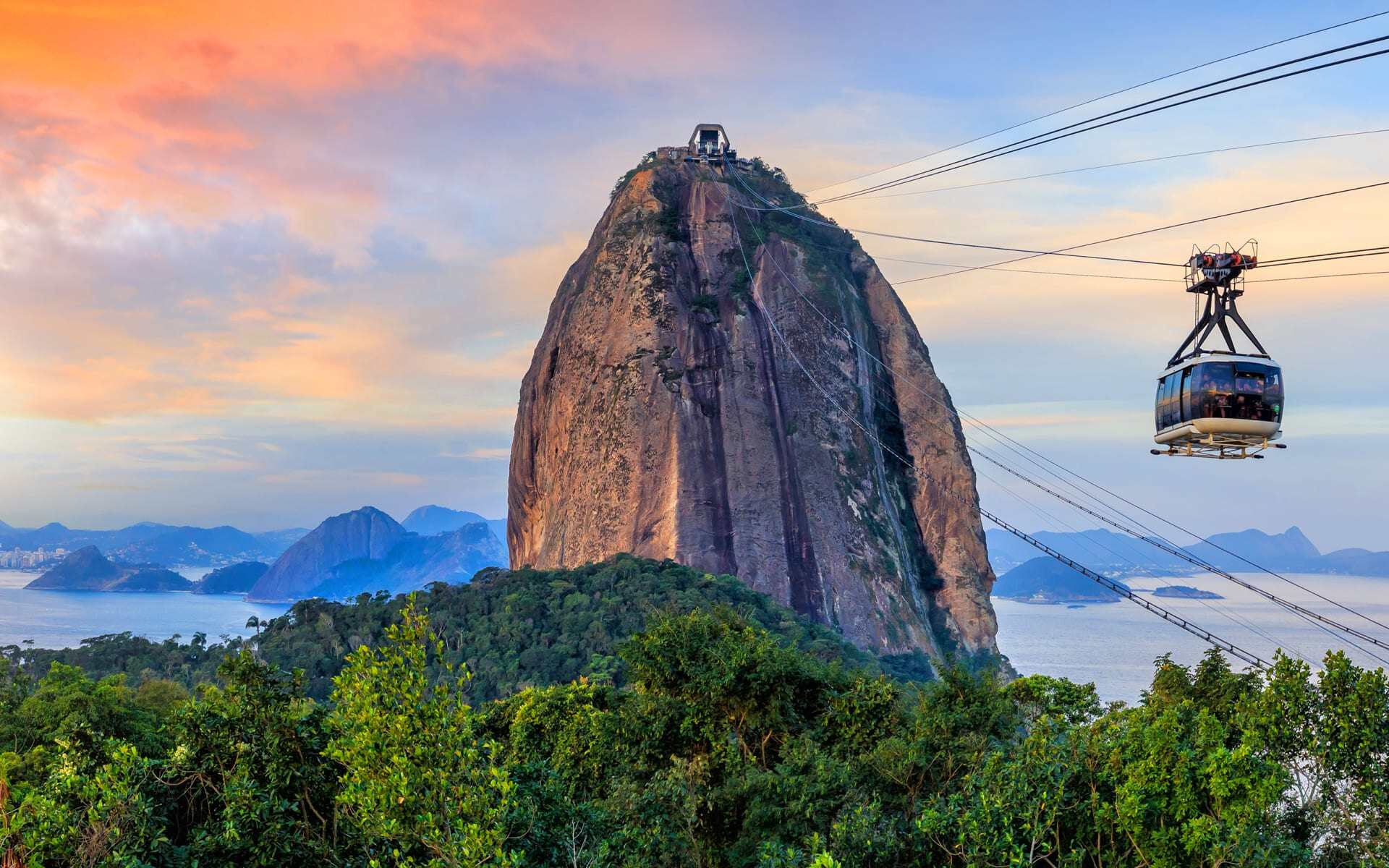 A cable car heads to the peak of Sugarloaf Mountain on a sunny day.