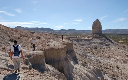 Some guests wander the rocky, desert landscapes near the lodge.