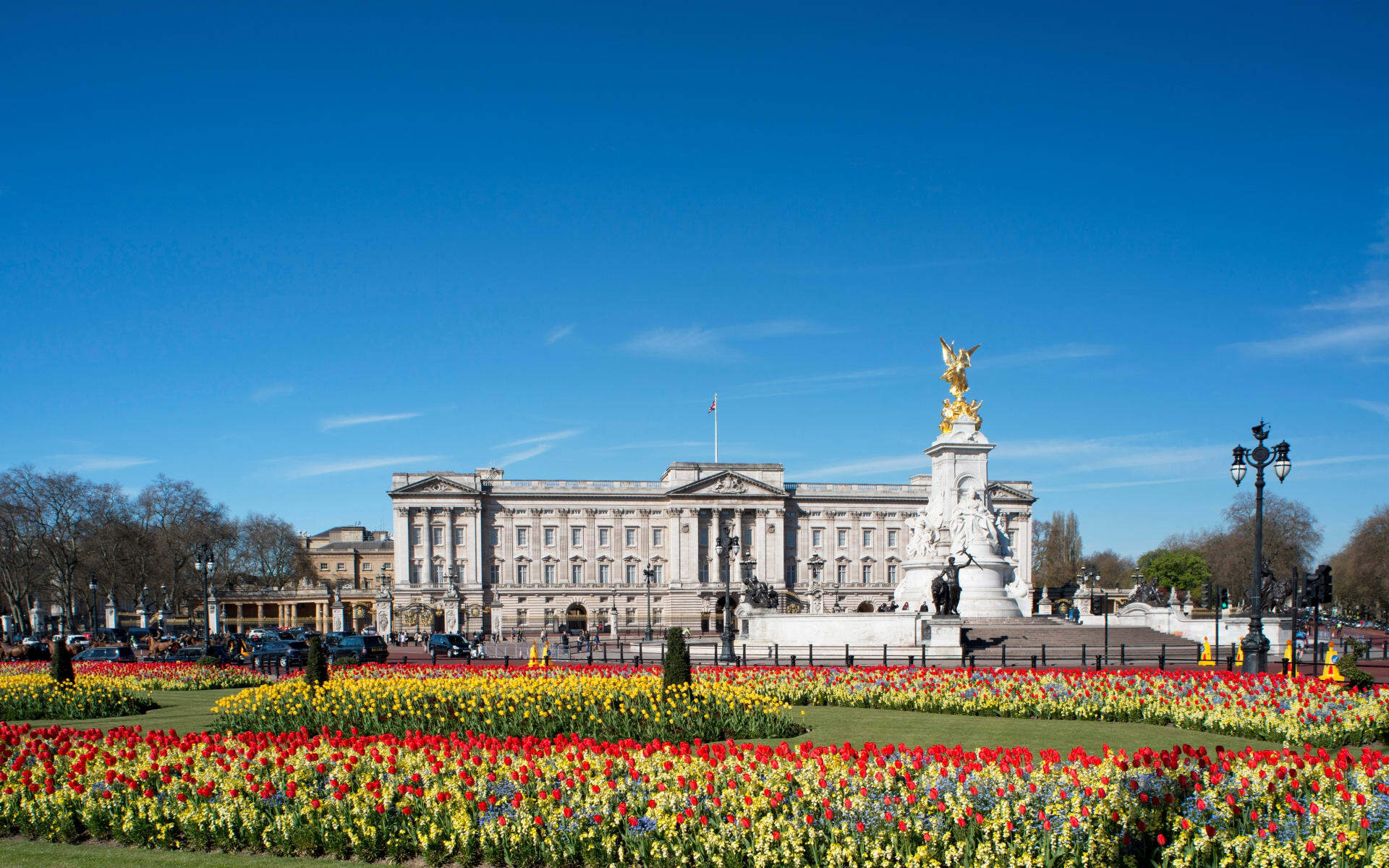 Buckingham palace is surrounded by colourful flowers.