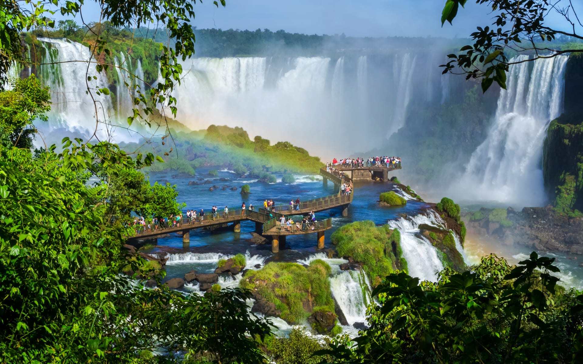 Iguazu Falls dazzles with cascading waters as a crowd of people watch on.