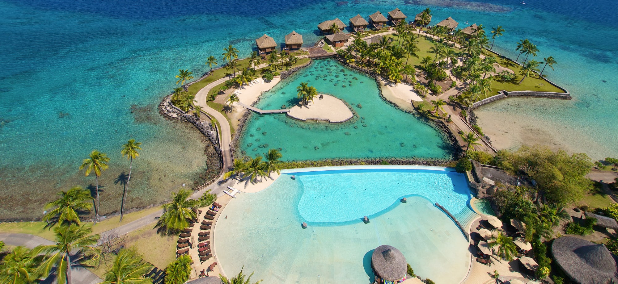 InterContinental Tahiti's pool overlooks a turquoise lagoon and overwater villas. 