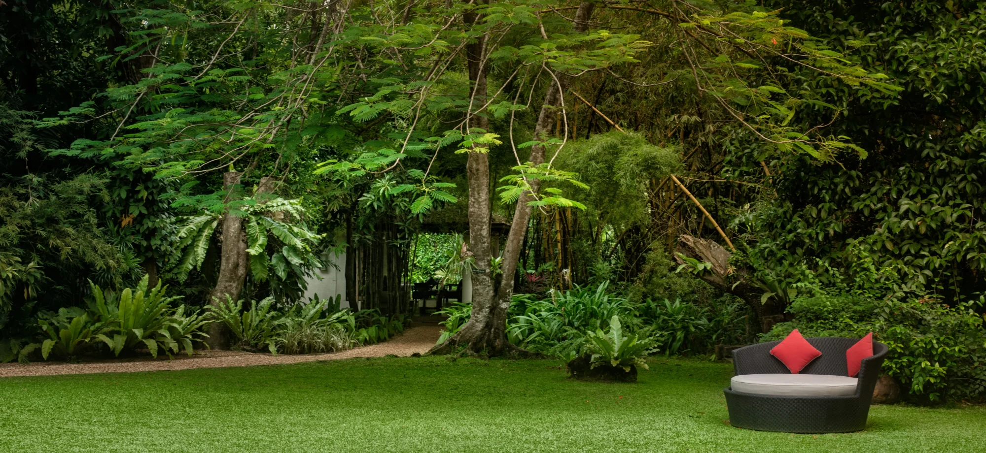 The gardens at the Wallawwa are lusciously green, equipped with outdoor sofas.