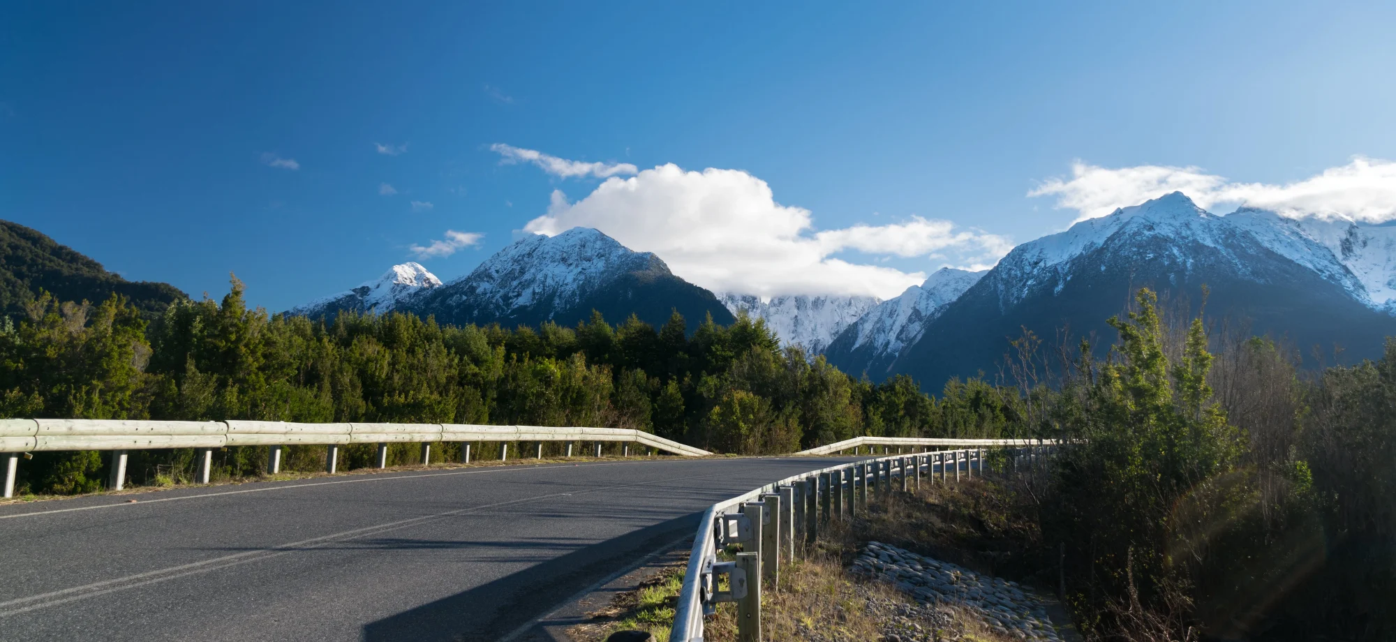 The road in Carretera Austral passes snow-capped mountains. 