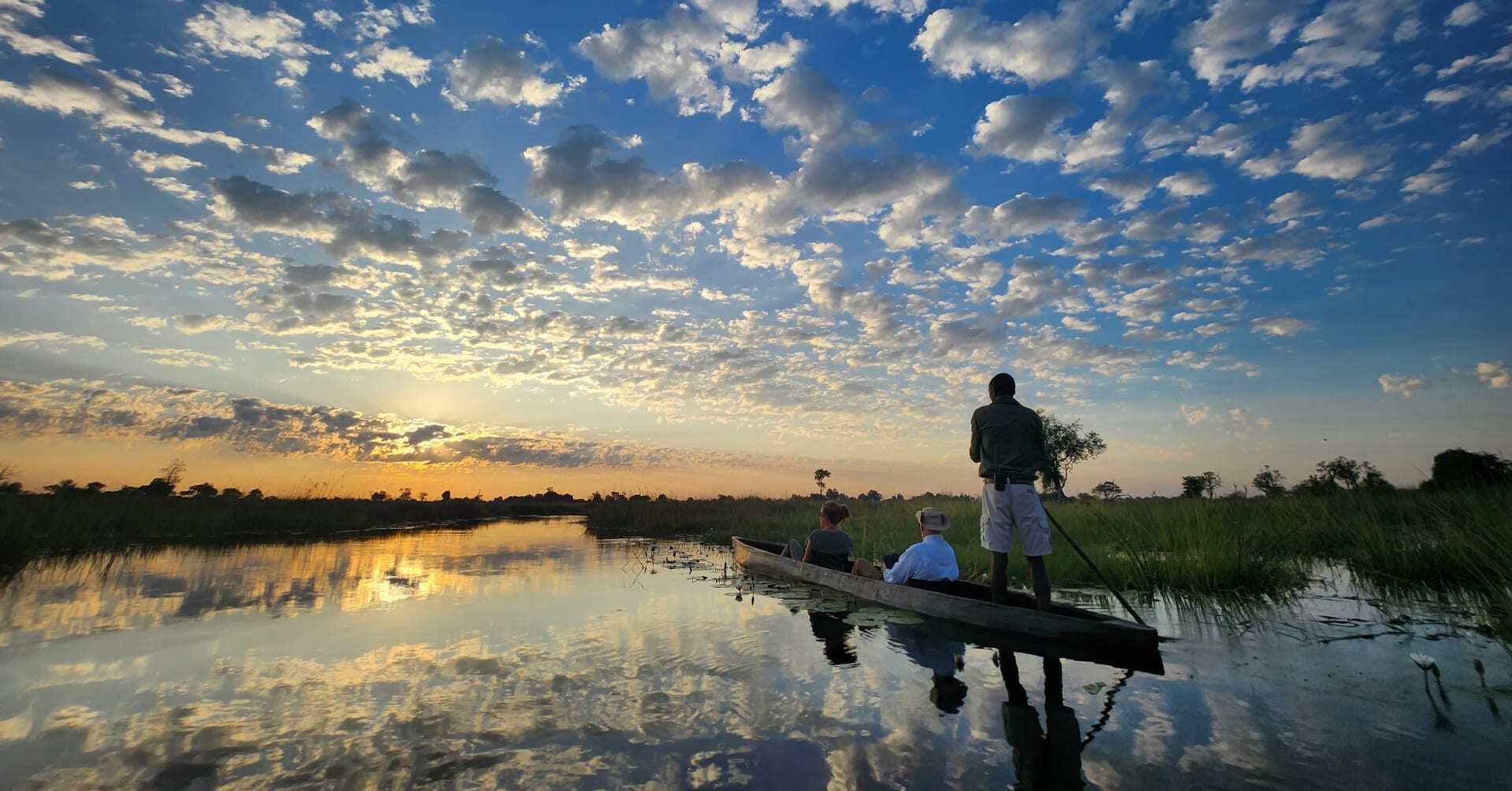 People enjoy a dug-out canoe ride in the Okavango Delta.